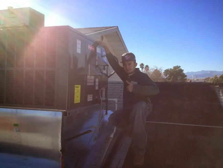 HVAC technician performing Air Duct Cleaning on a rooftop unit in Fox Chapel